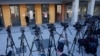 TV cameras are seen during a stakeout in front of the High Court in Belgrade, Serbia, Jan. 29, 2024. A trial started Monday for the parents of a teenager who is accused of killing 10 people and injuring six in a mass shooting at his school last May.