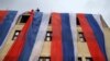 FILE - Activists unfurl Bosnian Serb flags on a building on the Serb Republic's national holiday, banned by Bosnia and Herzegovina's constitutional court, in East Sarajevo, Jan. 9, 2023.