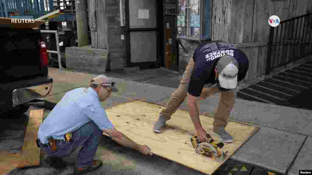 Los comerciantes de la Florida ponen madera contrachapada en las ventanas de sus tiendas previa a la llegada del ciclón.&nbsp;