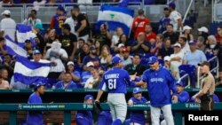 El lanzador de Nicaragua Erasmo Ramírez (61) celebra con el entrenador de pitcheo Cairo Murillo (4) en la cuarta entrada contra Venezuela en LoanDepot Park en Miami, Florida, EEUU. Foto proporcionada a Reuters por Sam Navarro-USA TODAY Sports.