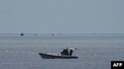 中国海警人员在南海争议海域乘坐充气船守在通往中国控制的黄岩岛的通道上。(2023年9月22日)