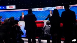 Fotógrafos toman fotos del presidente Joe Biden, a la derecha, y del candidato presidencial republicano, el expresidente Donald Trump, a la izquierda, durante una pausa en un debate presidencial organizado por CNN, el 27 de junio de 2024, en Atlanta.