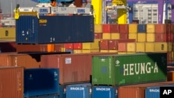 FILE - A crane lifts a shipping container at an automated port in Tianjin, China, Jan. 16, 2023.