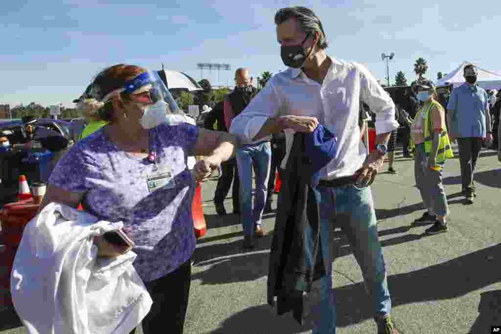 El comienzo de de la pandemia de COVID-19 hizo que cambiáramos la forma en la que nos relacionábamos por miedo al contagio. En esta imagen del 15 de enero de 2021, el gobernador de California Gavin Newsom y una trabajadora de la salud se saludan durante la apertura de un sitio de vacunación masiva.