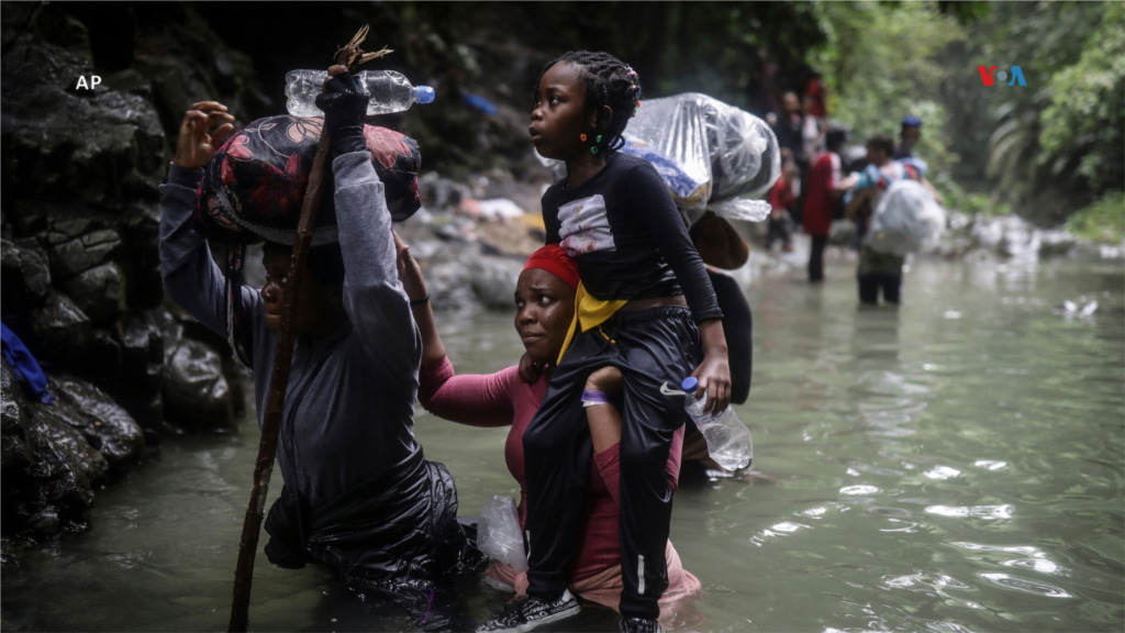  Migrantes haitianos atraviesan un río a su paso por el Tapón del Darién, desde Colombia a Panamá con el objetivo de llegar a Estados Unidos, el 9 de mayo de 2023. &nbsp; 