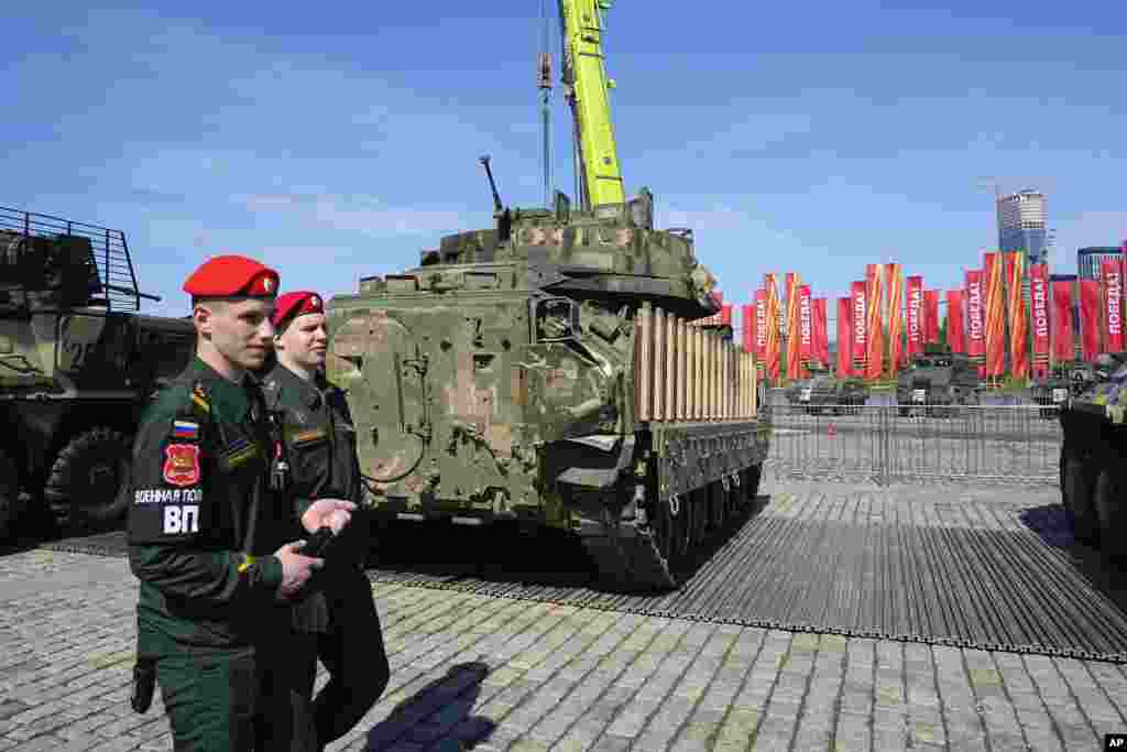 Soldados de la policía militar rusa pasan junto a un vehículo de combate Bradley M2A2.&nbsp;Los blogueros militares rusos establecieron paralelismos entre la muestra y las exhibiciones de equipo militar nazi capturado que la Unión Soviética mantuvo durante y después de la Segunda Guerra Mundial.