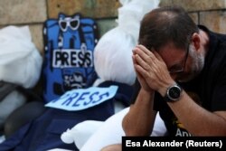 Un hombre reacciona durante una vigilia para recordar a los periodistas asesinados y heridos en medio del conflicto entre Israel y Hamás, frente a la Catedral de San Jorge, en Ciudad del Cabo, Sudáfrica, el 28 de enero de 2024.