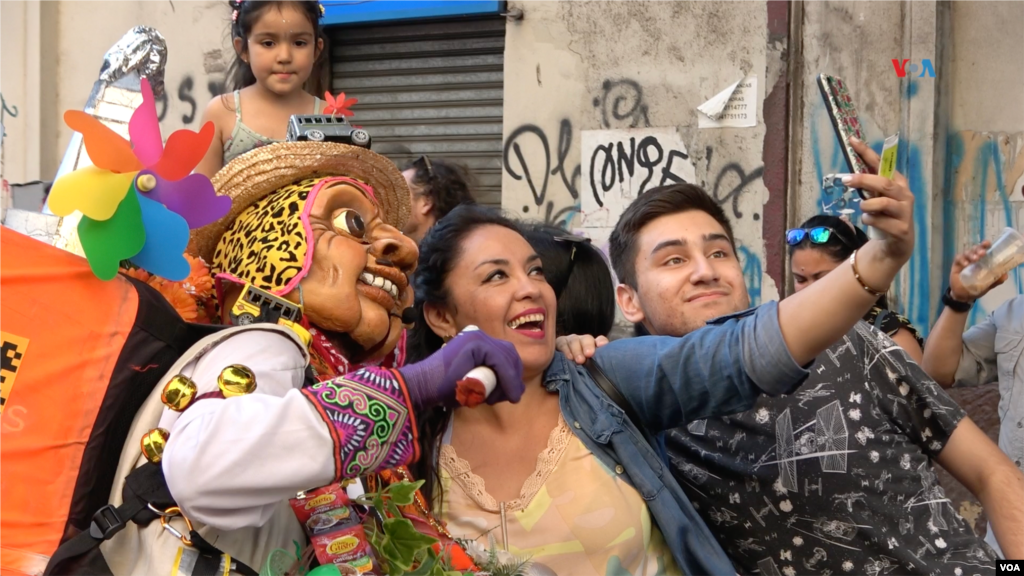 Familias chilenas se retratan con artistas de la compañía Pachakuna Guardianes de los Andes, que asiste al Festival Internacional Teatro a Mil, enero de 2024.