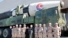 FILE - North Korean leader Kim Jong Un and his daughter attend a photo session with the scientists, engineers, military officials and others involved in the test-fire of the country's Hwasong-17 intercontinental ballistic missile, Nov. 27, 2022.