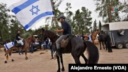 Un hombre a caballo porta una bandera de Israel poco antes de iniciar la cabalgata por la liberación de Idan Shtivi, el 5 de diciembre de 2023.