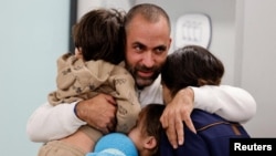 Avihai Brodutch akiwakumbatia watoto wake Oria Brodutch, 4, na Ofri Brodutch, 10, pamoja na mke wake Hagar Brodutch baada ya kuungana nao tena Israel, November 26 kufuatia kuachiliwa kwao na Hamas.