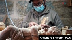 Un palestino talla figuras religiosas en madera de olivo, artesanías que no saben cuándo venderán por la ausencia de turistas debido al conflicto Israel-Hamás, en Belén, Cisjordania, el 7 de diciembre de 2023. 