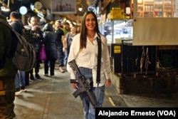 Una joven recluta pasea con su arma reglamentaria por el mercado Mehané Yehudá, en Jerusalén con la que dice sentirse segura.