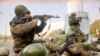 ARCHIVO - Soldados del ejército ruso disparan sus metralletas para cubrir a sus compañeros soldados que cargan sus armas durante el asalto destinado a expulsar a los legisladores de línea dura y sus partidarios dentro del edificio del parlamento el 4 de octubre de 1993 en Moscú.