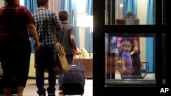 ARCHIVO - Inmigrantes que solicitan asilo y que fueron reunidos tras haber sido separados llegan a un hotel el 23 de julio de 2018, en San Antonio. 