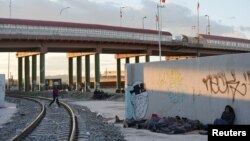 Migrantes venezolanos solicitantes de asilo que fueron expulsados de regreso a México desde El Paso, Texas, EEUU, hacen campamento improvisado junto al Puente Internacional Paso del Norte en Ciudad Juárez, México, el 18 de octubre de 2022.