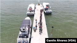 Imágenes de drone muestran a los migrantes abordando un bote en Necoclí, Colombia, con destino a Acandí, para luego adentrarse al Tapón del Darién y continuar su ruta hacia Estados Unidos, el 12 de octubre de 2022. 
