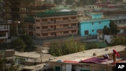 Mujeres limpian sus sábanas en el techo en el área de Sherpur en Kabul, Afganistán. Foto de archivo. (Foto AP/Anja Niedringhaus)