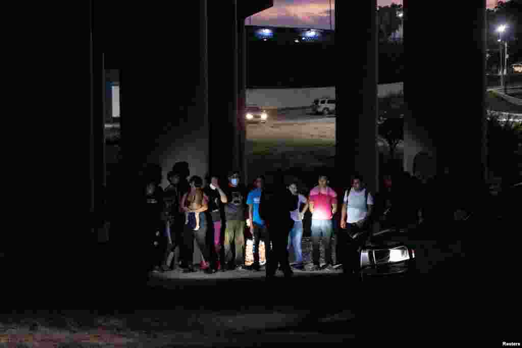 Decenas de migrantes cruzan el Río Grande hasta el lado estadounidense, donde agentes de aduanas de Estados Unidos los procesan.