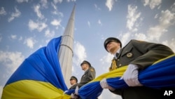 En esta foto proporcionada por la Oficina de Prensa Presidencial de Ucrania, los soldados de la guardia de honor se preparan para izar la bandera nacional de Ucrania durante las celebraciones del Día de la Bandera Estatal en Kiev, Ucrania, el 23 de agosto de 2022.