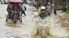 Commuters travel through a flooded street after heavy rains at Guwahati, in the northeastern Indian state of Assam, June 26, 2012. 