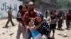 Palestinians run following what police said was an Israeli air strike on a house in Gaza city July 9, 2014. At least 23 people were killed across Gaza, Palestinian officials said.