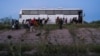 Migrantes que buscan asilo ingresan a un autobús de la Patrulla Fronteriza de EEUU tras cruzar el río Grande desde México, el 26 de julio de 2022.