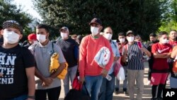 Migrantes llevan cobertores de la Cruz Roja después de viajar desde Texas hasta Union Station, cerca del Capitolio federal, el 27 de abril de 2022, en Washington.