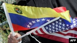 Vecinos de un edificio de apartamentos en Nueva York portan banderas de Venezuela y EEUU durante un acto de entrega de combustible para calefacción a bajo costo, el 17 de noviembre de 2006 en el Bronx, Nueva York. [Archivo]