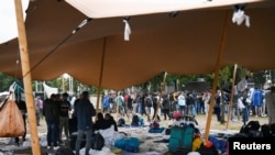 Los refugiados esperan al aire libre en el suelo húmedo del principal centro de recepción de solicitantes de asilo, en Ter Apel, Países Bajos, el 17 de agosto de 2022.