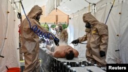 Miembros del Servicio de Emergencia del Estado asisten a simulacros de respuesta a desastres nucleares en medio del bombardeo de la planta de energía nuclear de Zaporizhzhia, en Zaporizhzhia, Ucrania, el 17 de agosto de 2022.