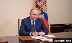 El presidente ruso Vladimir Putin asiste a una ceremonia de izado de bandera en el ferry Marshal Rokossovsky a través de un enlace de video en su residencia en las afueras de Moscú, Rusia, el 4 de marzo de 2022. Sputnik/Alexey Nikolsky/Kremlin vía REUTERS.