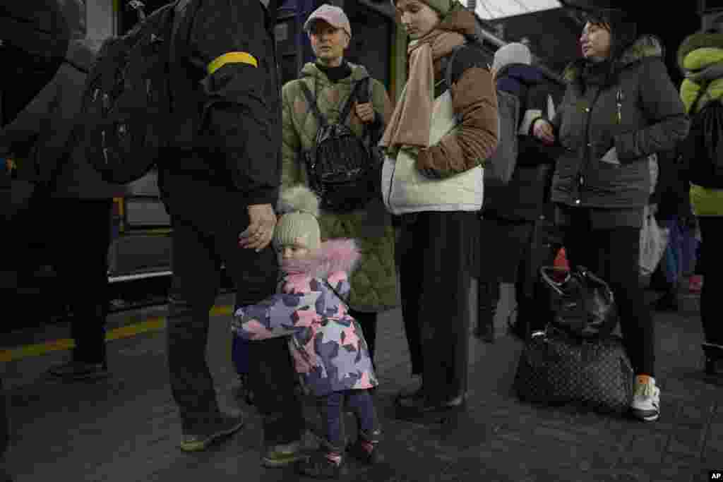 Un niño agarra la pierna de un hombre antes de abordar un tren con destino a Lviv, en Kiev, Ucrania, el jueves 3 de marzo de 2022.&nbsp;
