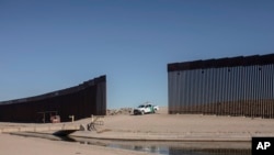 Un vehículo de la Oficina de Aduanas y Protección Fronteriza de Estados Unidos espera a un grupo de migrantes nicaragüenses mientras caminan desde Algodones, México, hacia la frontera sur estadounidense para entregarse a las autoridades y solicitar asilo,