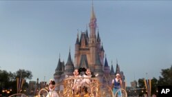 ARCHIVO - Mickey y Minnie Mouse actúan durante un desfile al pasar por el Castillo de Cenicienta en el parque temático Magic Kingdom en Walt Disney World en Lake Buena Vista, Florida, el miércoles 15 de enero de 2020.