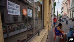 Juanto a anuncios de ventas de productos electrónicos aparece el símbolo del bitcoin como moneda de cambio en El Salvador, el 2 de febrero de 2022.