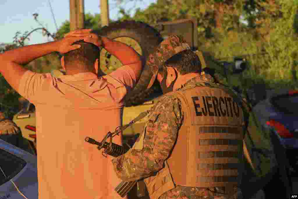 Una foto publicada por la oficina de prensa de la Presidencia de El Salvador muestra a un soldado registrando a un hombre durante una operación de búsqueda de pandilleros en Soyapango, El Salvador.