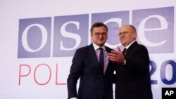El Ministro de Relaciones Exteriores de Polonia, Zbigniew Rau, a la derecha, da la bienvenida a su homólogo ucraniano, Dmytro Kuleba, a la izquierda, durante una reunión de alto nivel de la Organización para la Seguridad y la Cooperación en Europa en Lodz, Polonia, el 1 de diciembre de 2022.