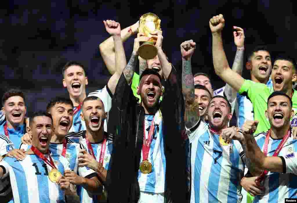 El argentino Lionel Messi levanta el trofeo de la Copa del Mundo junto a sus compañeros de equipo mientras celebran tras ganar el Mundial de Qatar 2022.&nbsp;