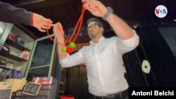 Pau Martínez Llop, propietario de "El Rey de la Magia", suele realizar una selección de juegos que luego vende en su establecimiento de Barcelona, España. Foto: Antoni Belchi / VOA