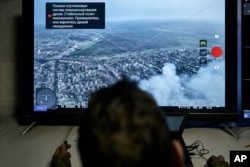 Un soldado ucraniano observa desde un centro de comando subterráneo en Bakhmut, región de Donetsk, Ucrania, el domingo 25 de diciembre de 2022. (Foto AP/Libkos)