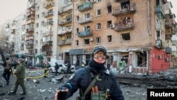 Un oficial de policía vigila un área alrededor de una casa destruida por los bombardeos mientras continúa el ataque de Rusia contra Ucrania, en Kiev, Ucrania, el 14 de marzo de 2022. REUTERS/Gleb Garanich