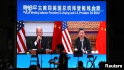 Una pantalla en un restaurante de Beijing muestra un encuentro virtual entre los presidentes Joe Biden y Xi Jinping, el 16 de noviembre de 2021.