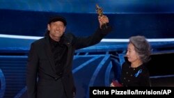 Youn Yuh-jung, a la derecha, entrega a Troy Kotsur el premio a la mejor interpretación de un actor en un papel secundario por "CODA" en los Oscar el domingo 27 de marzo de 2022 en el Dolby Theatre de Los Ángeles. (Foto AP/Chris Pizzello)