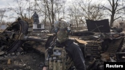 Un soldado ucraniano pasa junto a los restos de un tanque ruso en la aldea de Lukyanova, en las afueras de Kiev, mientras continúa la invasión rusa de Ucrania, el 27 de marzo de 2022.