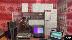 ARCHIVO - En esta fotografía tomada el 12 de octubre de 2021, el presentador de radio Ebrahim Parhar lee las noticias durante una transmisión en la estación de radio Urooj en la provincia de Farah. La estación de radio Urooj una vez se asoció con periodistas que producían boletines de noticias, pero desde que los talibanes llegaron a la ciudad, Ebrahim Parhar se sienta solo, transmitiendo horas de sermones religiosos. (Foto de AFP)