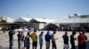 Migrantes de Haití, que regresaron al lado mexicano de la frontera para evitar la deportación, hacen cola para desayunar en un albergue del Instituto Nacional de Migración (INM) en Ciudad Acuña, México, el 25 de septiembre de 2021.