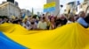 Manifestantes desfilan con la bandera ucraniana en el Obelisco de Buenos Aires, Argentina, en protesta de la invasión de Rusia, el 6 de marzo de 2022.
