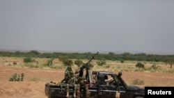 FILE - Niger's army soldiers ride on a pickup truck near Agadez, Niger, Oct. 29, 2019.
