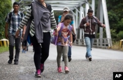 Migrantes hondureños con una niña caminan en grupo hacia Estados Unidos, mientras avanzan por Chiquimula, Guatemala, el martes 16 de octubre de 2018.